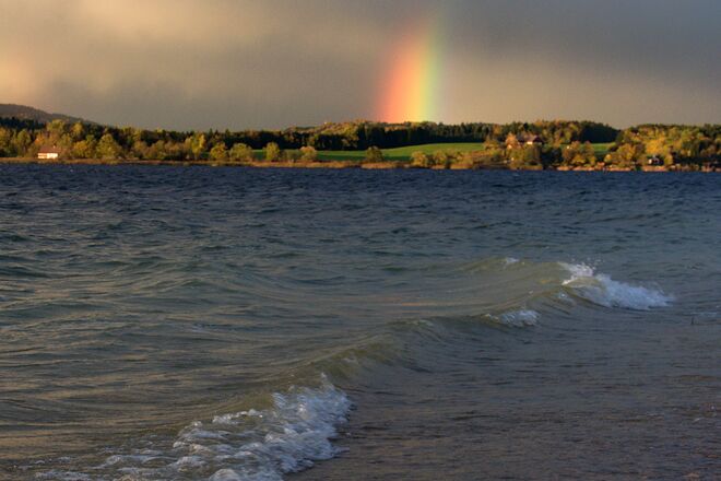 Regenbogen am See mit Wellen