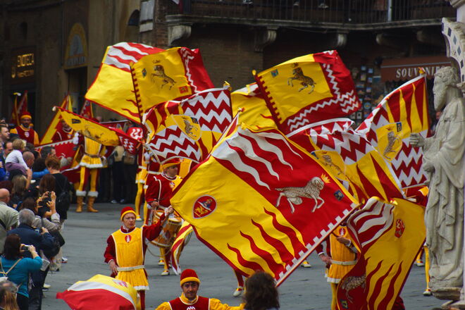 Fahnenschwinger ziehen durch die Straßen von Siena