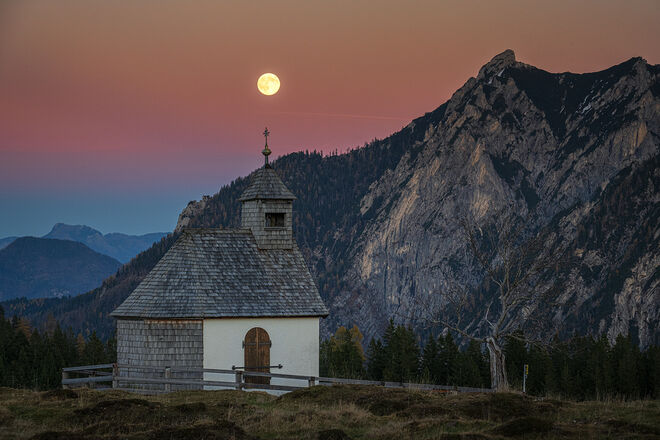 Der Supermond geht über der Postalmkapelle auf.