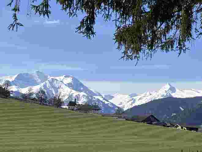 Grüne Wiese, frischer Schnee im Gebirge
