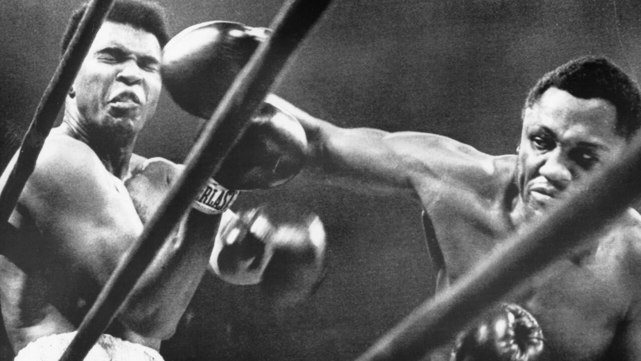 Muhammad Ali fängt eine harte Rechte von Joe Frazier. Muhammad Ali fängt eine harte Rechte von Joe Frazier.