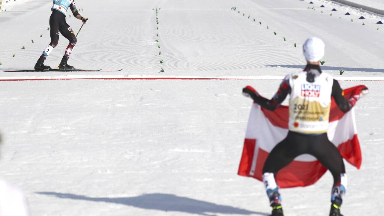 Lukas Greiderer bei der Fahrt über die Ziellinie, Johannes Lamparter erwartet ihn schon mit der Österreich-Fahne. 