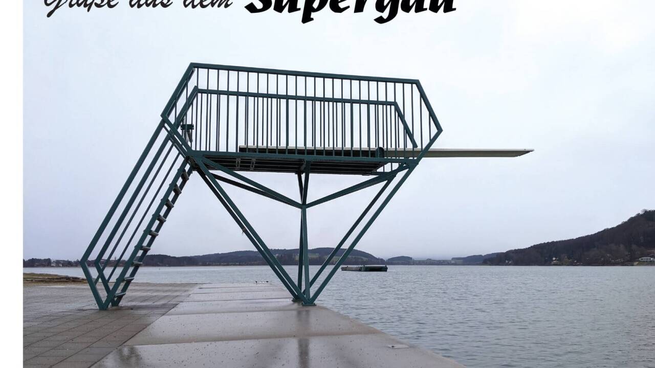 Ansichtskarte des Festivals „Supergau“ mit einem Bild aus dem Strandbad Mattsee. 