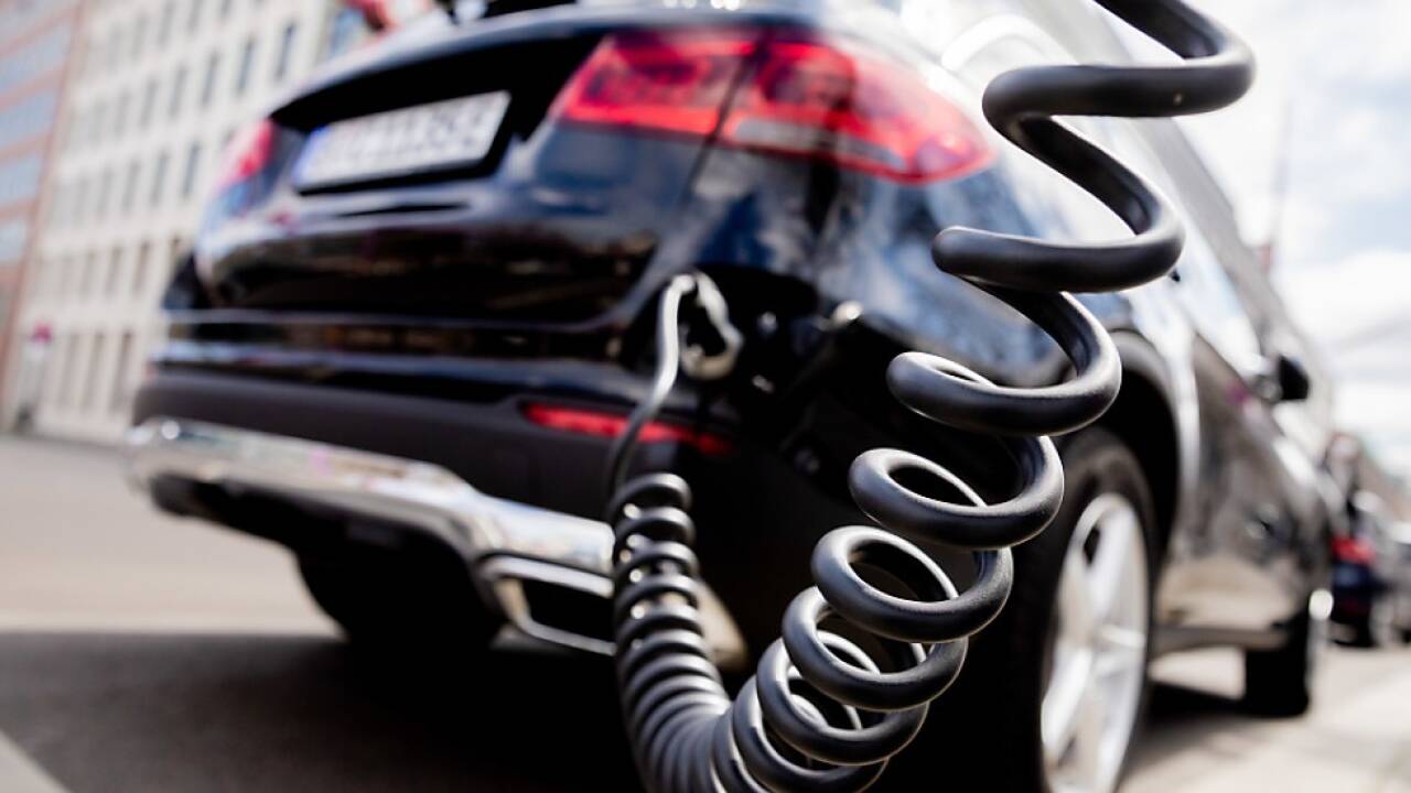 Auto mit Plug-in-Hybrid-Antrieb "tankt" an Ladesäule Auto mit Plug-in-Hybrid-Antrieb 'tankt' an Ladesäule