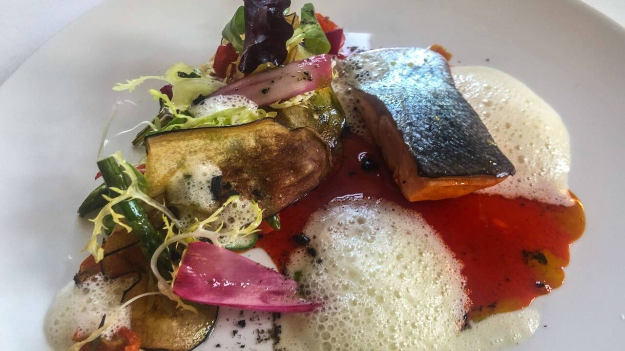 Teller mit im Fond entsafteter Paradeiser pochiertem Lachsl aus dem Wolfgangsee. Begleitet wird der Fisch von in entsaftetem Spitzpaprikafond angerichtetem Gemüsesalat. 