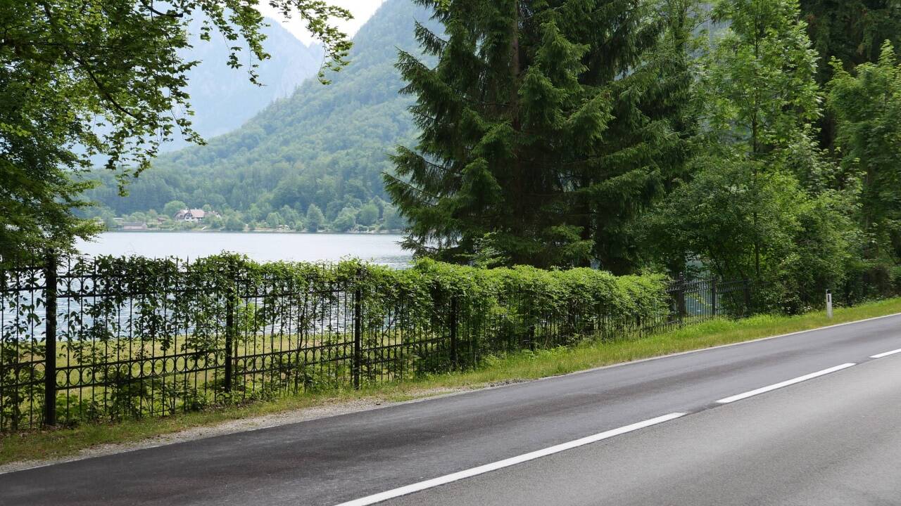 Zwischen den Bäumen ist ein Blick auf den Attersee zu erhaschen.  