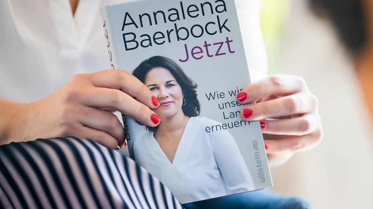 Baerbock hält ein Exemplar ihres Buches in Händen 