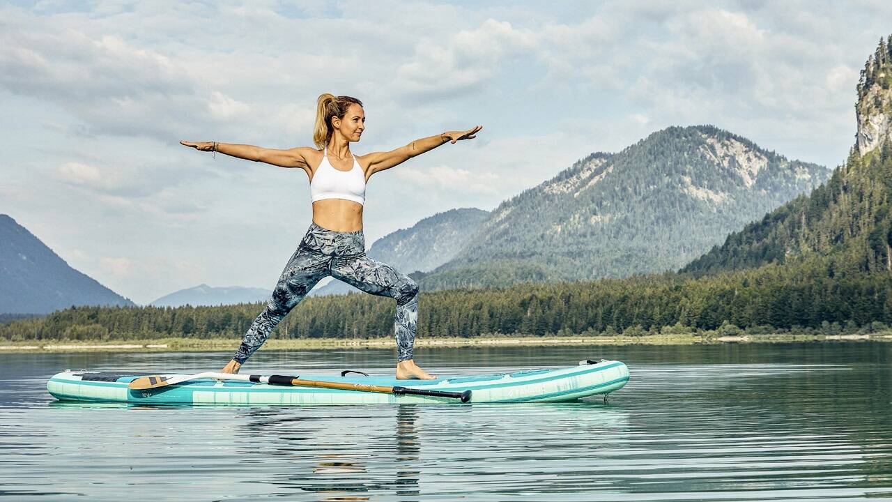 Julia Pross bei einer schwierigen Yogaposition auf dem Brett: dem Krieger II. 