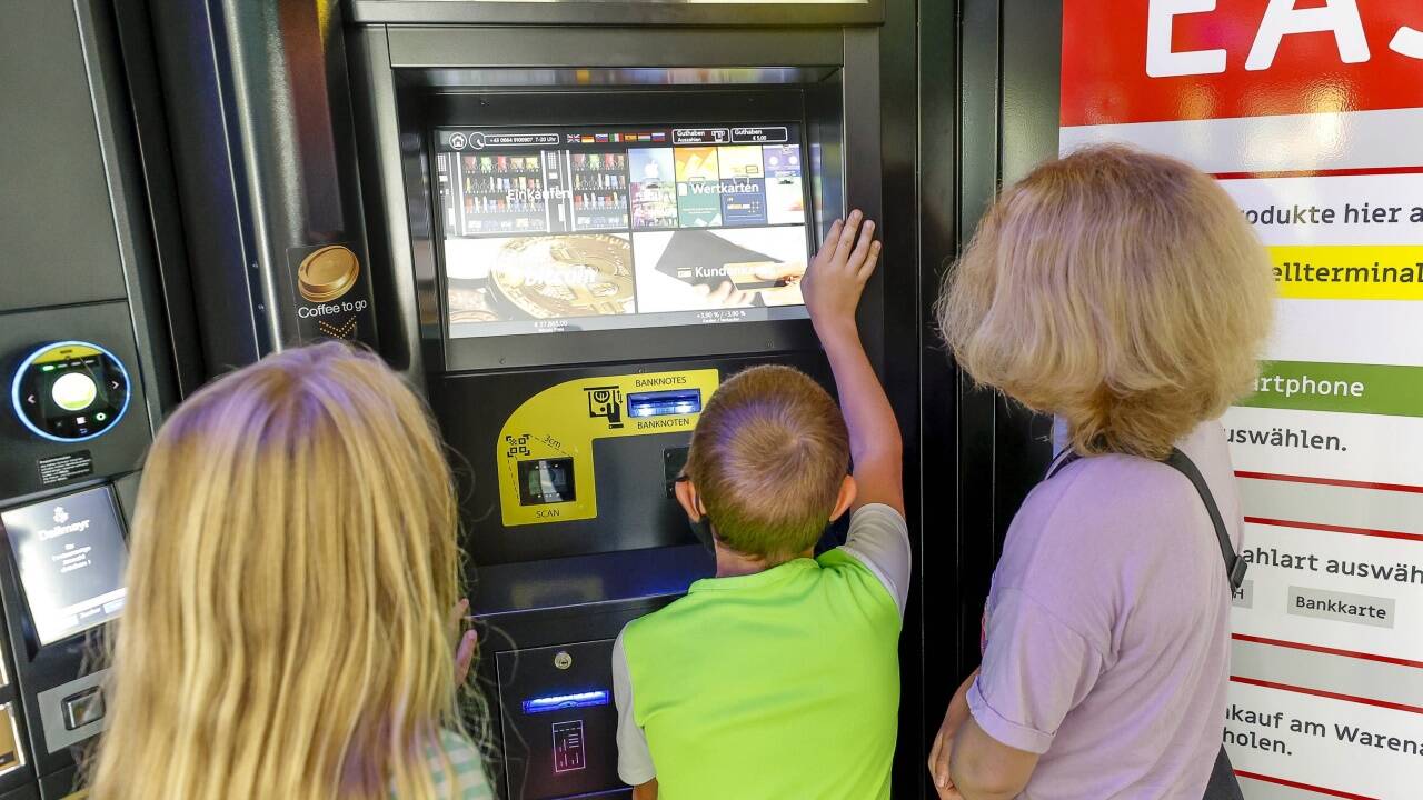 Kinder holen sich Getränke und Snacks an den Automaten. 