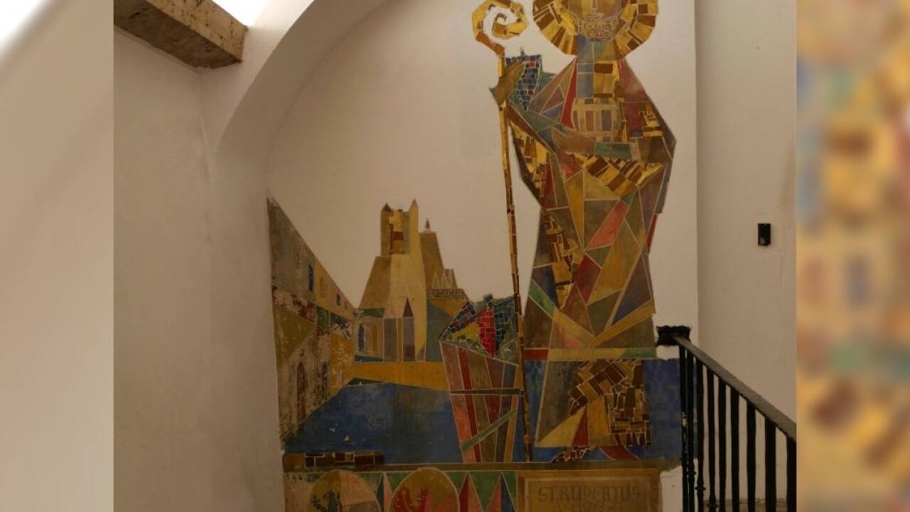 Der Heilige Rupert tritt auf diesem Wandmosaik als Weinheiliger auf.  