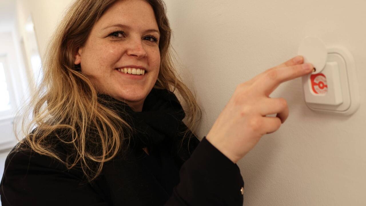 Hausleiterin Sabine Zeller vor einem Notfallknopf, mit dem die Polizei alarmiert werden kann. 