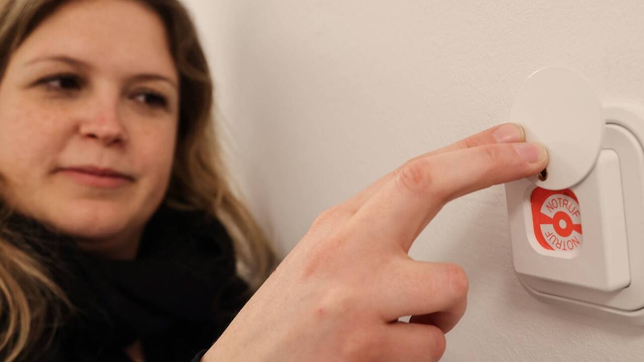 Hausleiterin Sabine Zeller vor einem Notfallknopf, mit dem die Polizei alarmiert werden kann. 