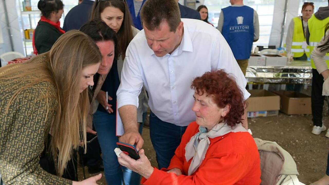 Eine Ukrainerin zeigt Takacs Fotos ihrer beschossenen Wohnung 