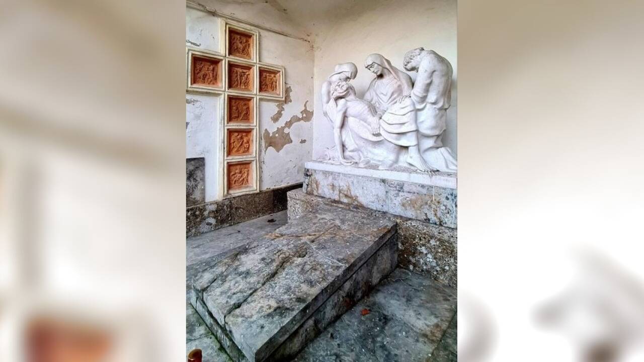 Die Pieta mit der knienden Maria Magdalena (links) und dem Apostel Johannes. Links das in die Wand eingelassene Kreuz aus Relieftafeln.  