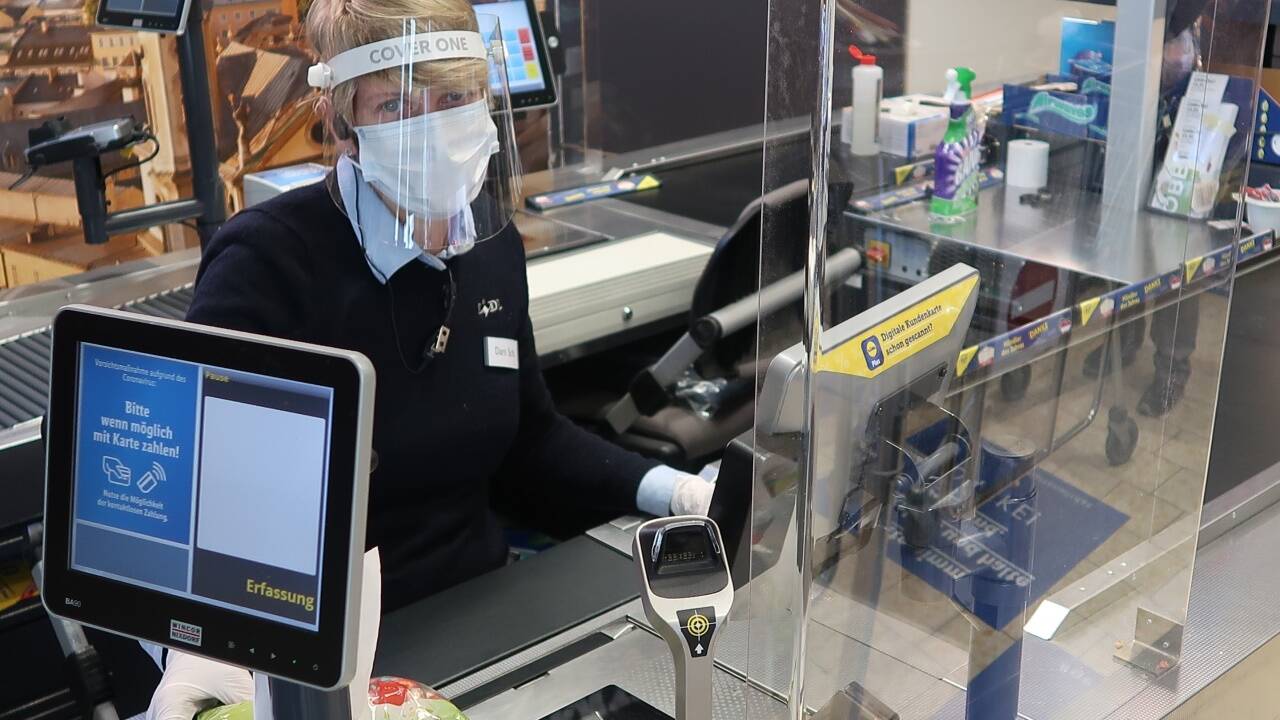 Supermarkt-Kassierin während der Pandemie hinter Plexiglasscheibe (Symbolbild). Diese müsse aus Sicherheitsgründen bleiben, fordert der Betriebsrat. Supermarkt-Kassierin während der Pandemie hinter Plexiglasscheibe (Symbolbild). Diese müsse aus Sicherheitsgründen bleiben, fordert der Betriebsrat.