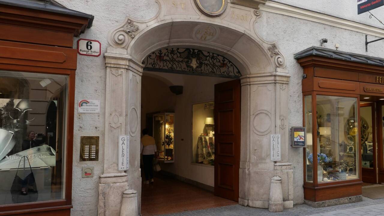 Im Durchhaus der Sigmund-Haffner-Gasse 6 in Salzburg hängt eine der Frauenspuren-Tafeln.  