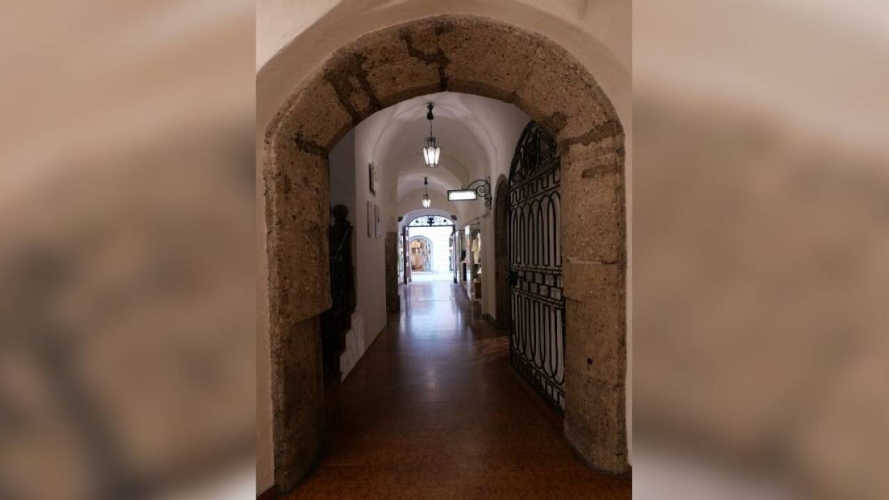 Im Durchhaus der Sigmund-Haffner-Gasse 6 in Salzburg hängt eine der Frauenspuren-Tafeln.  