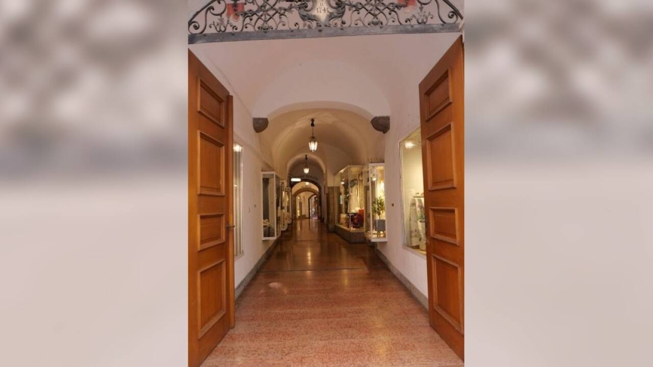 Im Durchhaus der Sigmund-Haffner-Gasse 6 in Salzburg hängt eine der Frauenspuren-Tafeln.  