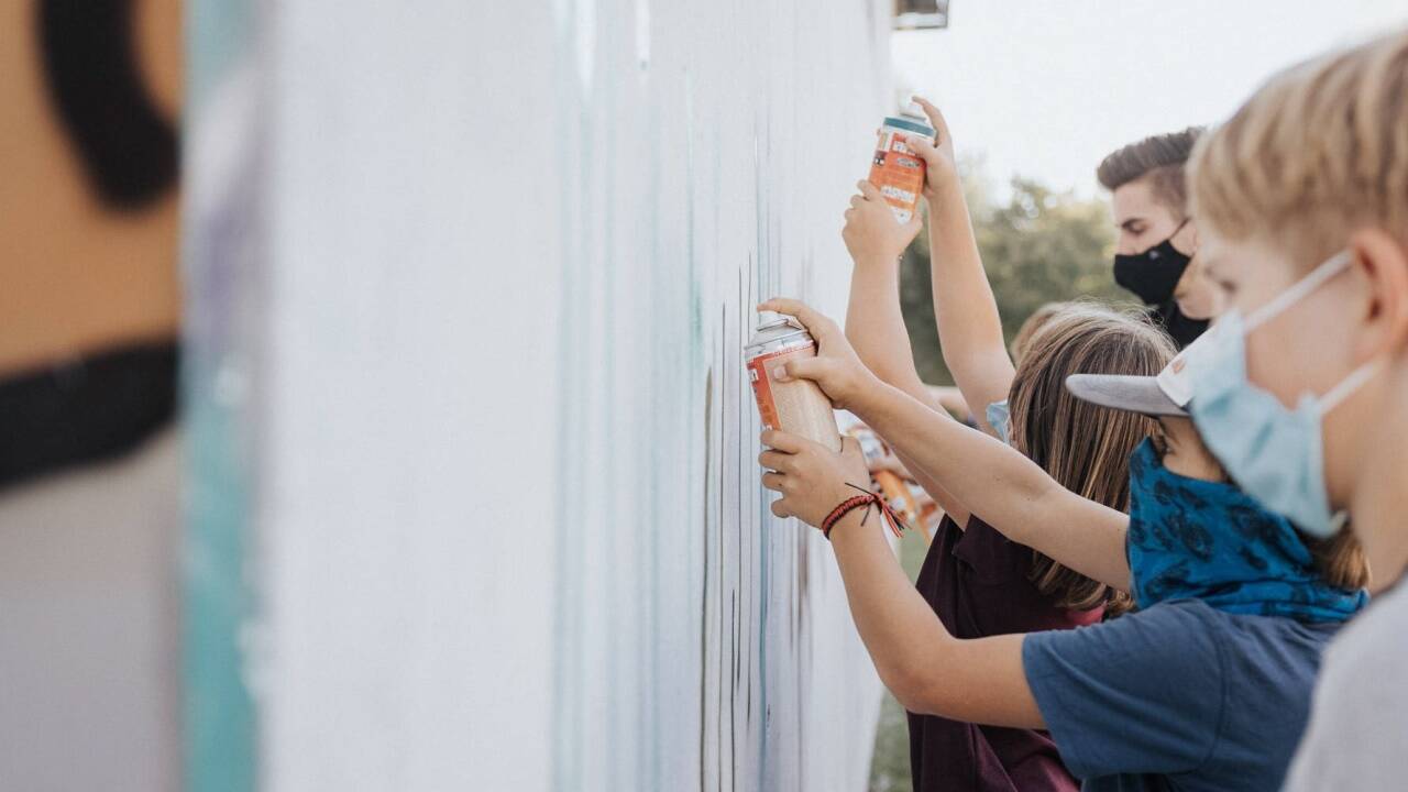 Kinder beim Sprayen im Graffiti-Workshop. 