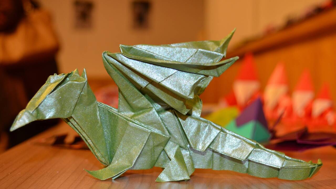 Die hohe Kunst des Faltens beziehungsweise der Falten, dargestellt an einem kleinen grünen Drachen. 