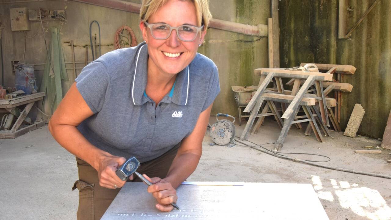  Dani Horner-Gartner beim Gravieren der Gedenktafel aus Untersberger Marmor für den Festakt in Mühldorf in Bayern. 