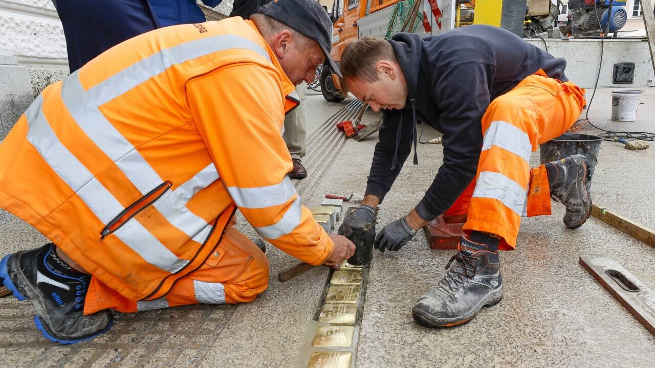 Mitarbeiter des Bauhofs verlegten die 13 Stolpersteine vor dem Landesgericht Salzburg.  