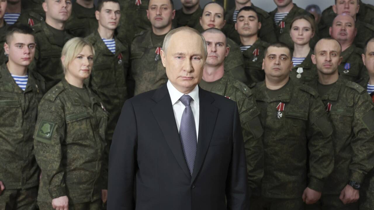 Wladimir Putin hielt seine Neujahrsrede diesmal umringt von Soldaten. Die Frau neben ihm tauchte schon öfters in Propaganda-Videos in unterschiedlichen Rollen auf: als Soldatin, Seglerin, fromme Christin.  Wladimir Putin hielt seine Neujahrsrede diesmal umringt von Soldaten. Die Frau neben ihm tauchte schon öfters in Propaganda-Videos in unterschiedlichen Rollen auf: als Soldatin, Seglerin, fromme Christin.