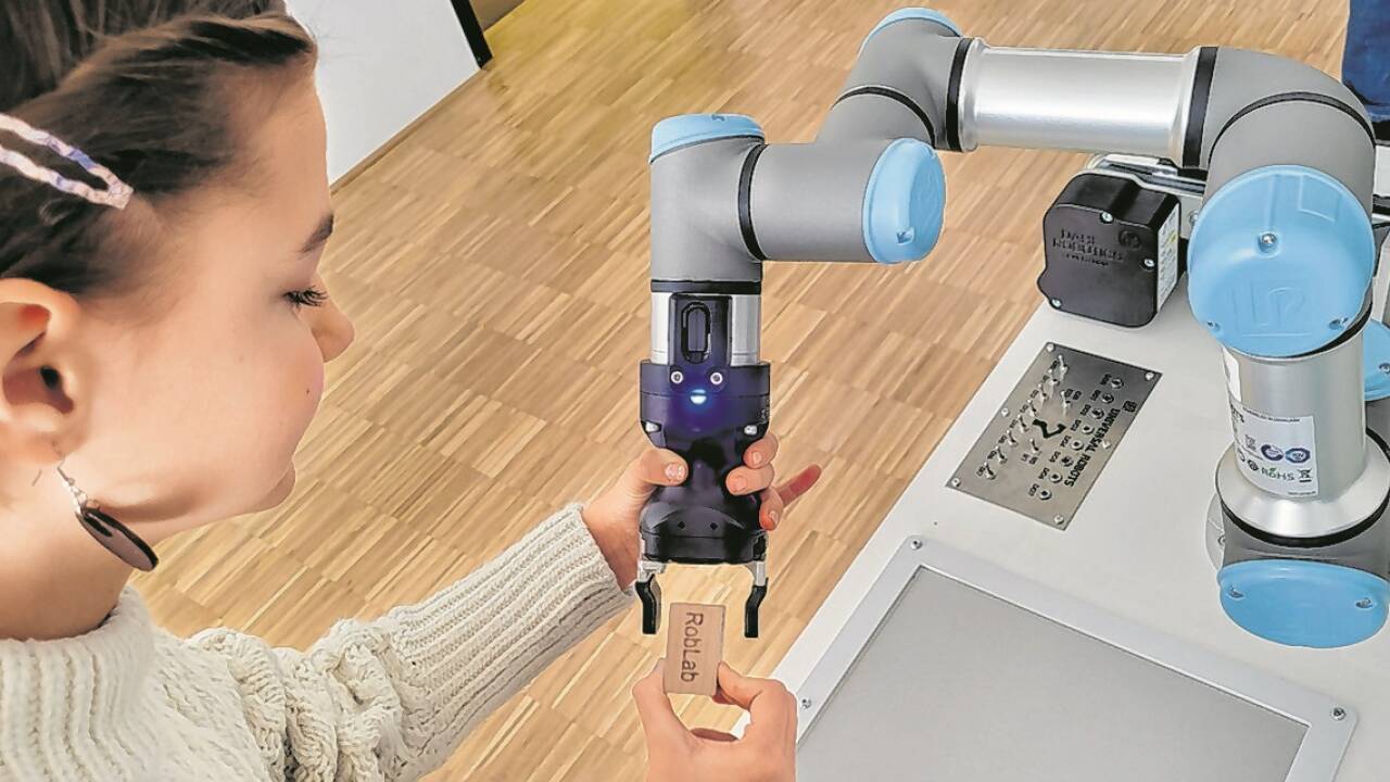 Katharina arbeitet mit einem kollaborativen Roboter, der mit Menschen interagiert.  