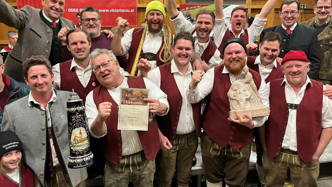 So schauen Sieger aus: Die Pass Siezenheim II holte wie im Vorjahr den Sieg beim Gemeindeschnalzen in Wals-Siezenheim und eroberte außerdem nach dem fünften bisherigen Sieg den Wanderpokal aus Untersberger Marmor. Auch Bürgermeister Joachim Maislinger (links hinten) gratulierte. 