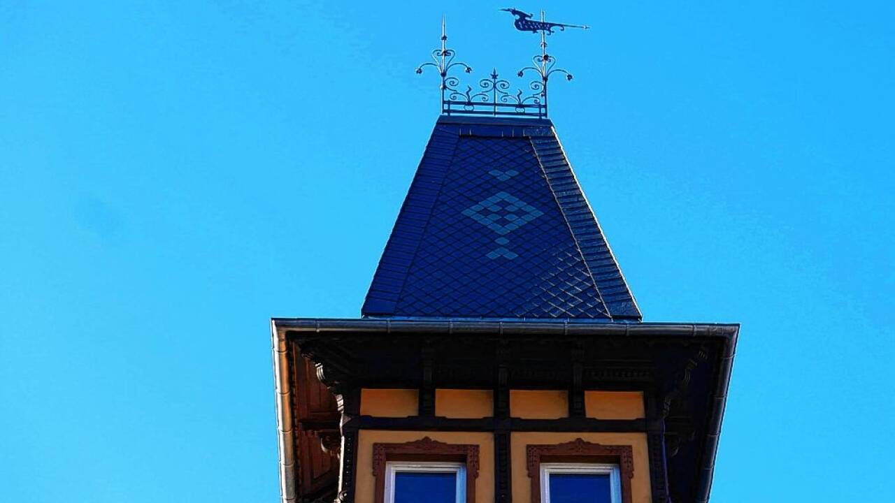 Das schiefergedeckte Turmdach krönt ein Wetterhahn.  