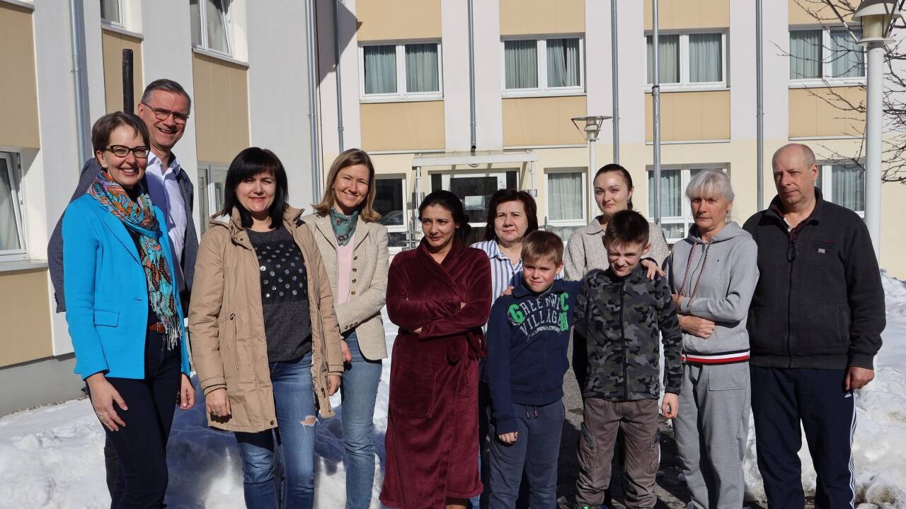 Flüchtlinge und ehrenamtliche Helfer vor dem Kolpinghaus.  