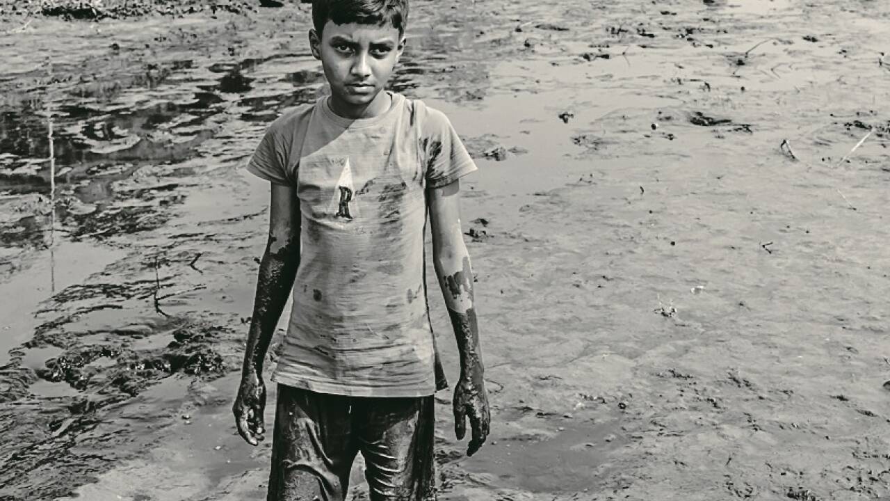 Kinderarbeit und Kinderhochzeiten sind in Dhaka die Regel. Ein Bub, der einen entleerten See nach Fischen absucht. 