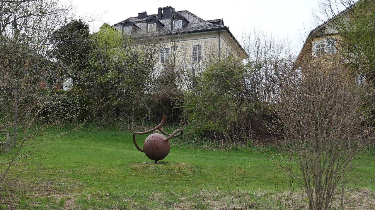 Die Steinskulptur wacht am Weiher von Schloss Rif in Hallein.  
