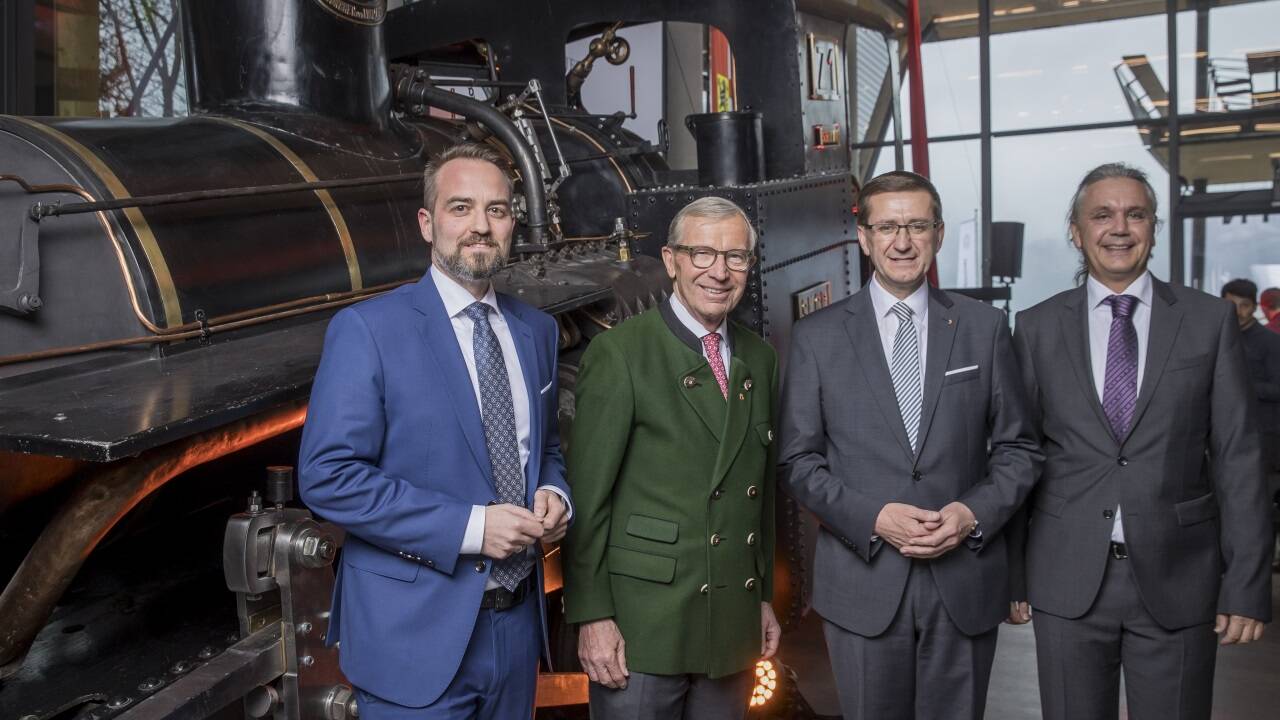 Salzburg AG Vorstandssprecher Michael Baminger, LH Wilfried Haslauer, der oberösterreichische Landesrat Markus Achleitner und Salzburg AG Tourismus GmbH-Geschäftsführer Mario Mischelin vor einer alten Dampflok. 