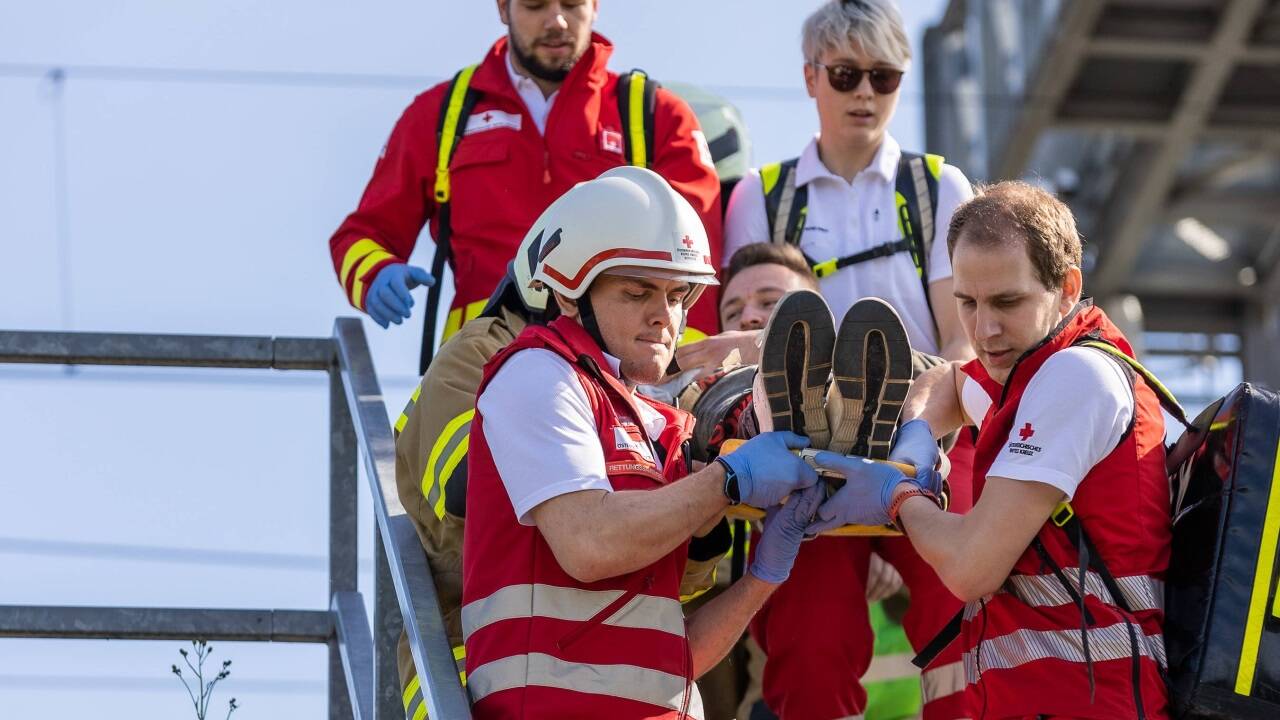 Rot-Kreuz-Helfer beim Abtransport von Verletzten.  