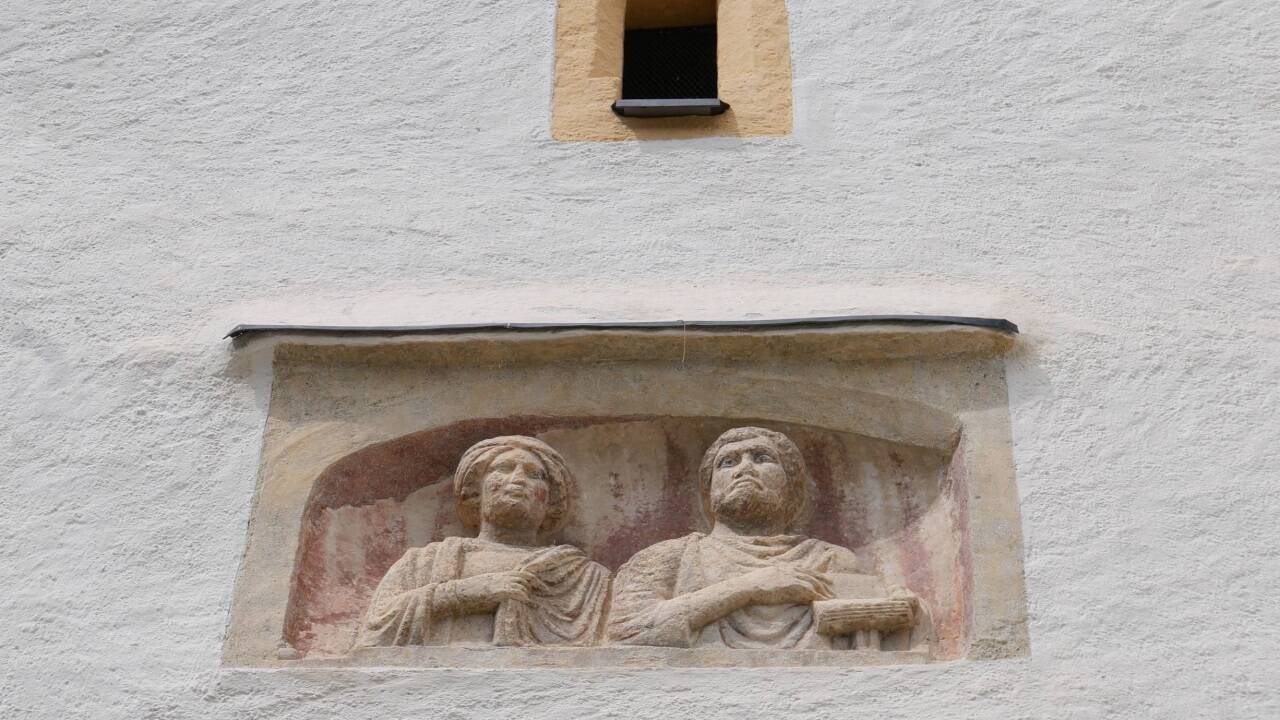 Ein Porträtstein auf dem Kirchturm in St. Martin im Lungau.  