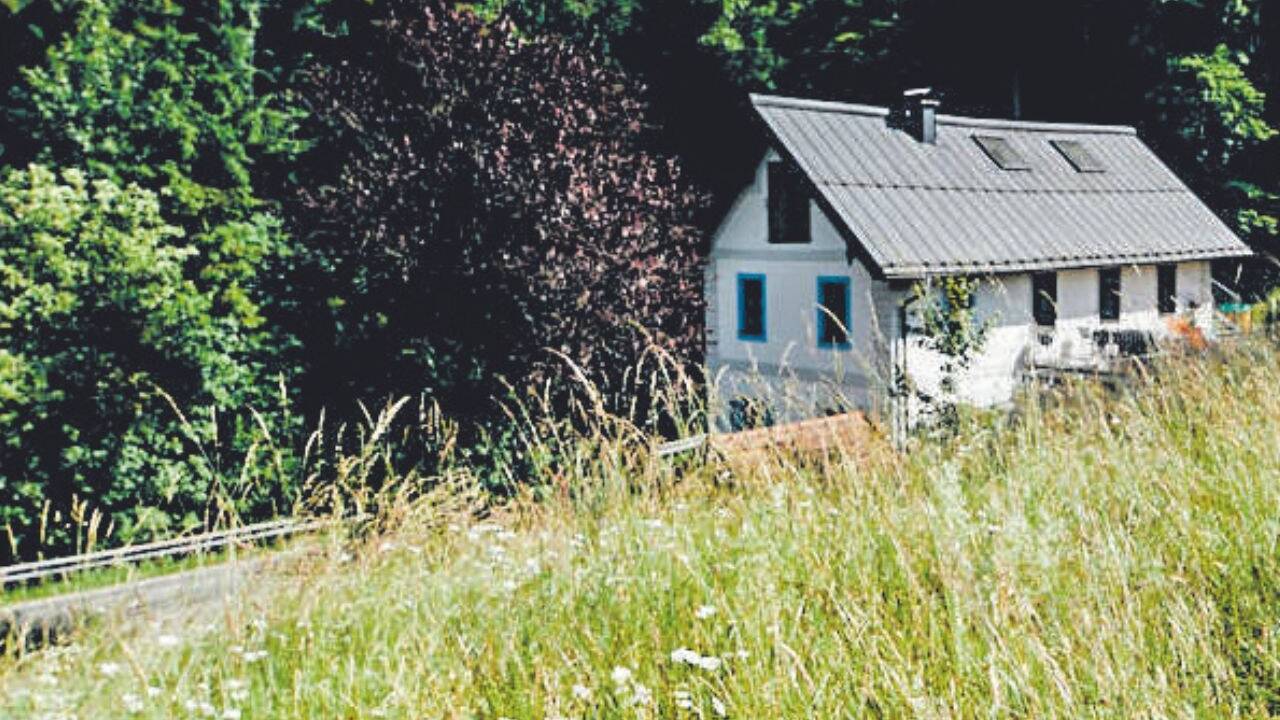 Das romantische zweistöckige Häuschen mit Satteldach und blauen Fensterfaschen.  
