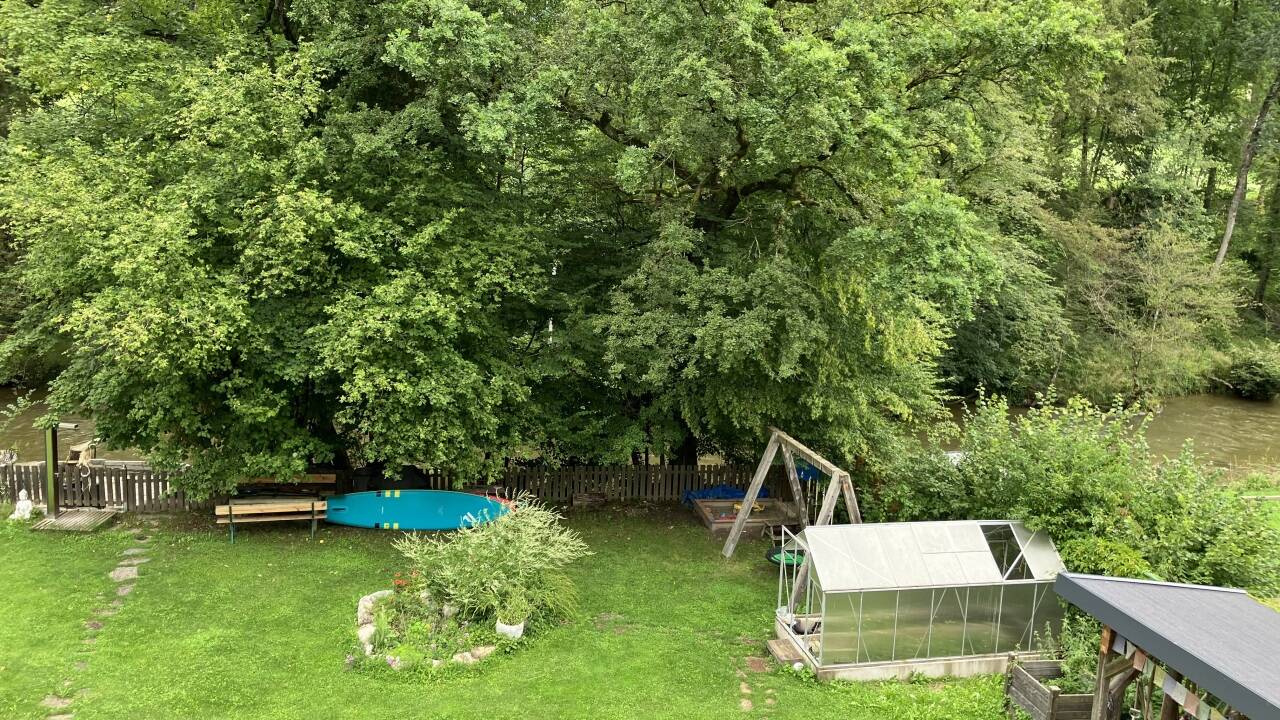 Blick auf den weitläufigen Garten und die Fischach.  Blick auf den weitläufigen Garten und die Fischach.
