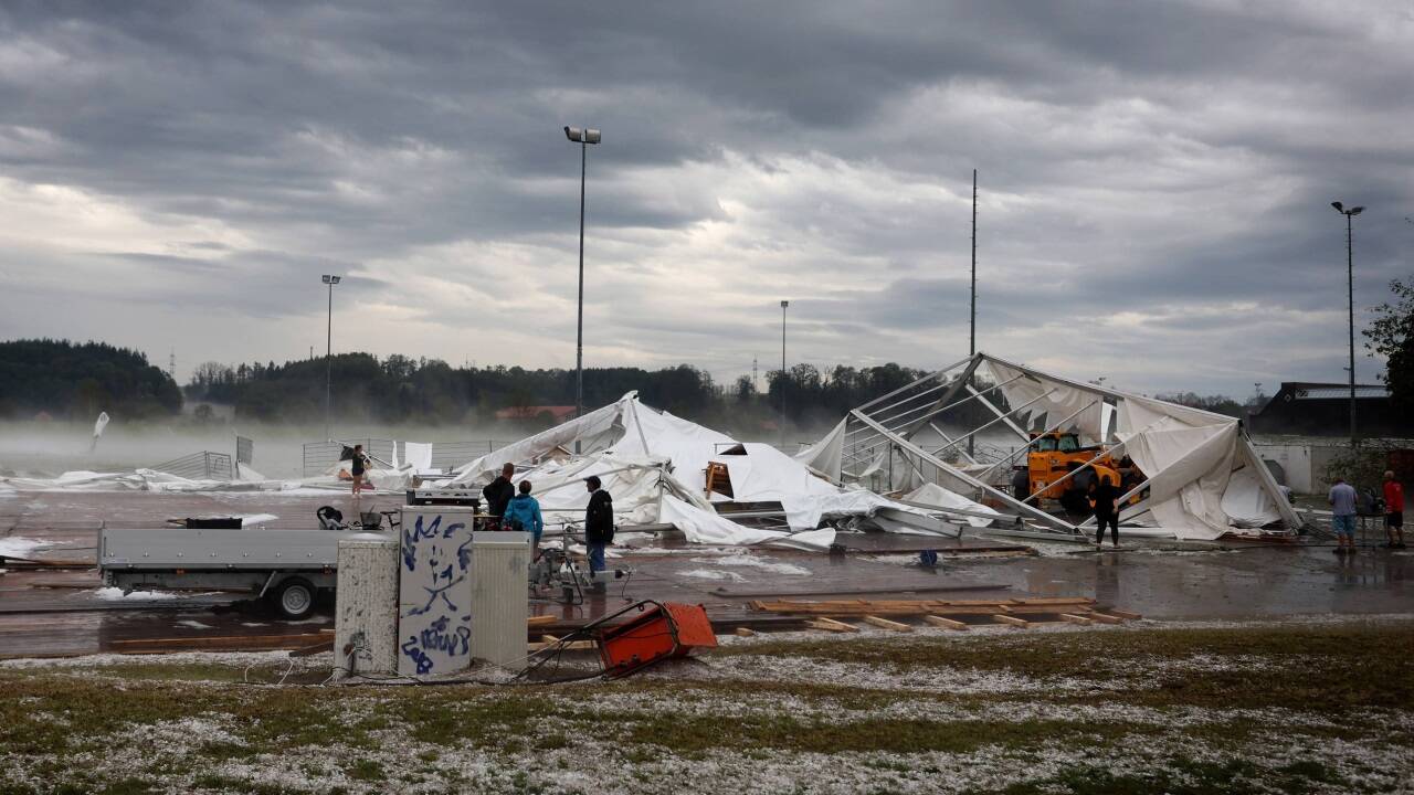 Bayern, Kissing: Reste eines vom Sturm zerstörten Festzeltes liegen am Ortsrand, auf der Wiese davor ist Hagel zu sehen.  