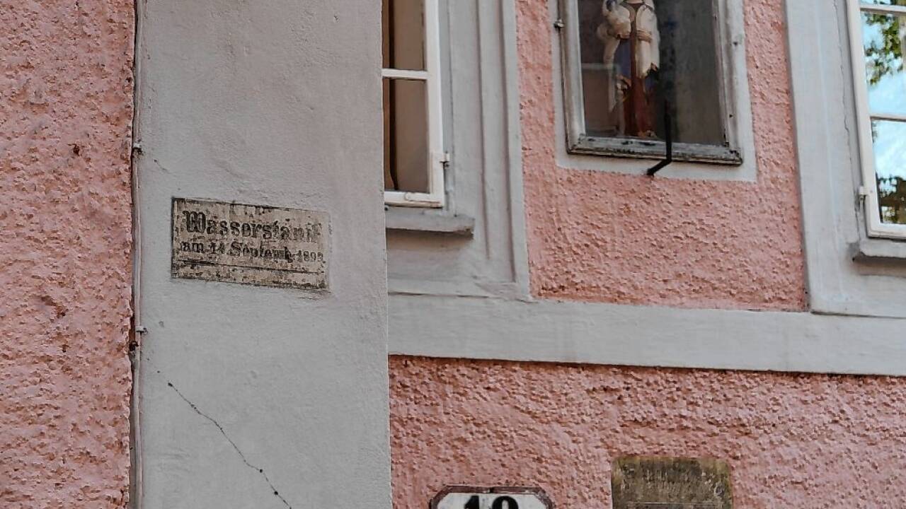 Die zwei Wassermarken auf dem Haus Nr. 18 samt der Madonna.  