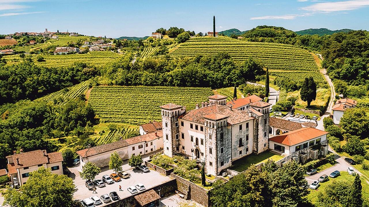 Weinland Slowenien: Blick auf Schloss Dobrovo, im Hintergrund das Dorf Medana. 