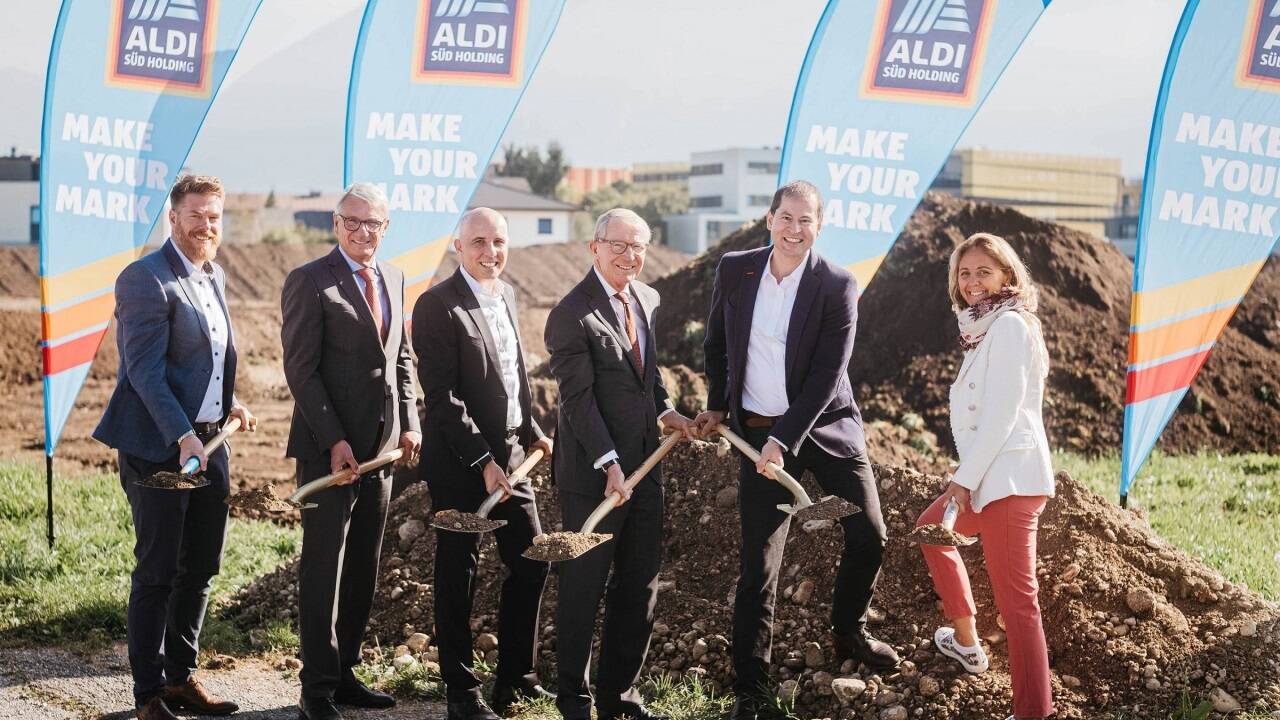Der Spartenstich erfolgte durch Harald Scheidtweiler, Director ALDI SÜD KG, Bürgermeister Harald Preuner, Roland Steinwender, Managing Director ALDI SÜD KG, Landeshauptmann Wilfried Haslauer, Andreas Geiger, Director ALDI Süd KG und Bürgermeister-Stellvertreterin Barbara Unterkofler (v. l.). 