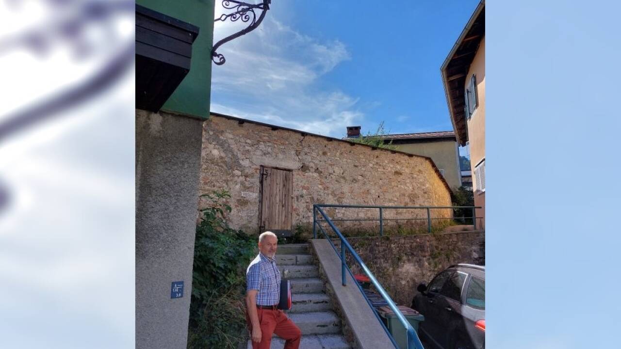 Wolfgang Wintersteller auf der Treppe, in welche die Goldgasse mündet. Hinter der Mauer befindet sich der Innenhofgarten, der verbaut werden soll. 