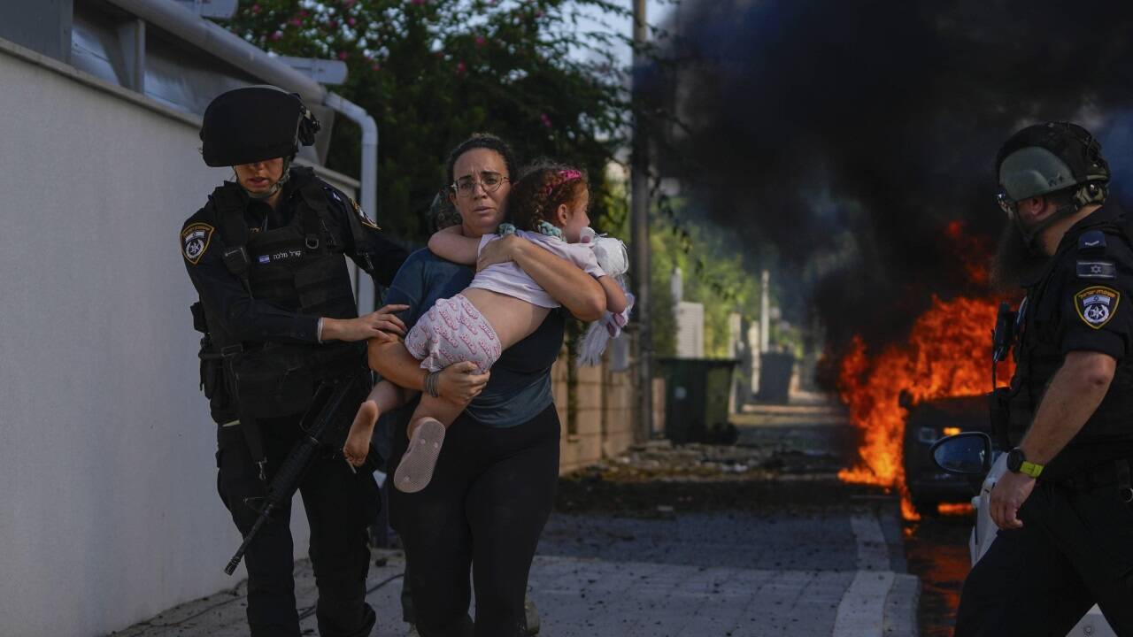 Polizisten evakuieren eine Frau und ihr Kind in Ashkelon, im Süden Israels.  