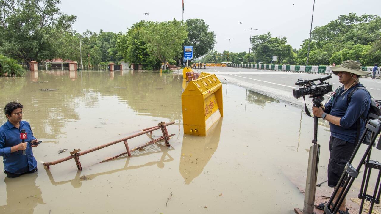 Ein Journalist berichtet zu Überflutungen im indischen Delhi.  
