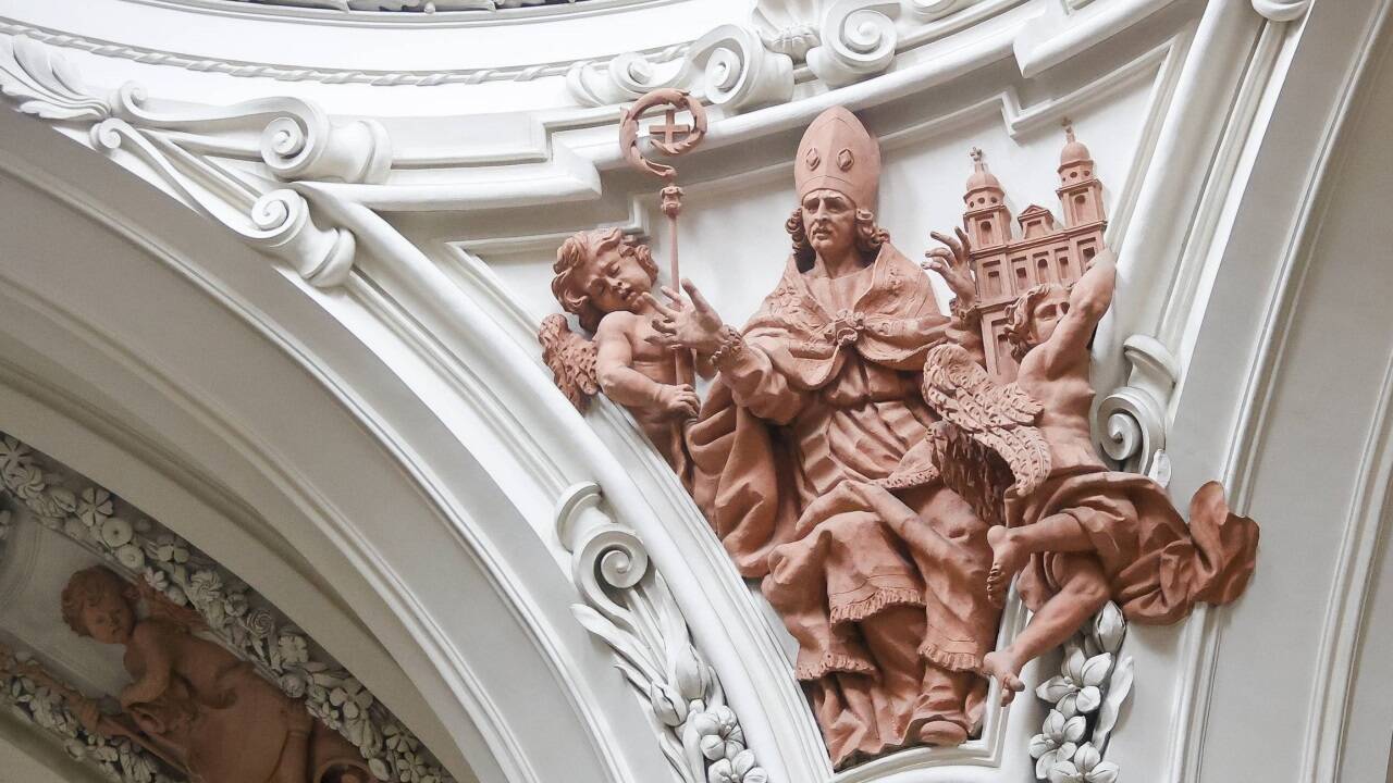 Hochrelief aus Stuck mit dem heiligen Virgil und zwei Engeln im Gewölbezwickel der Kirche.  
