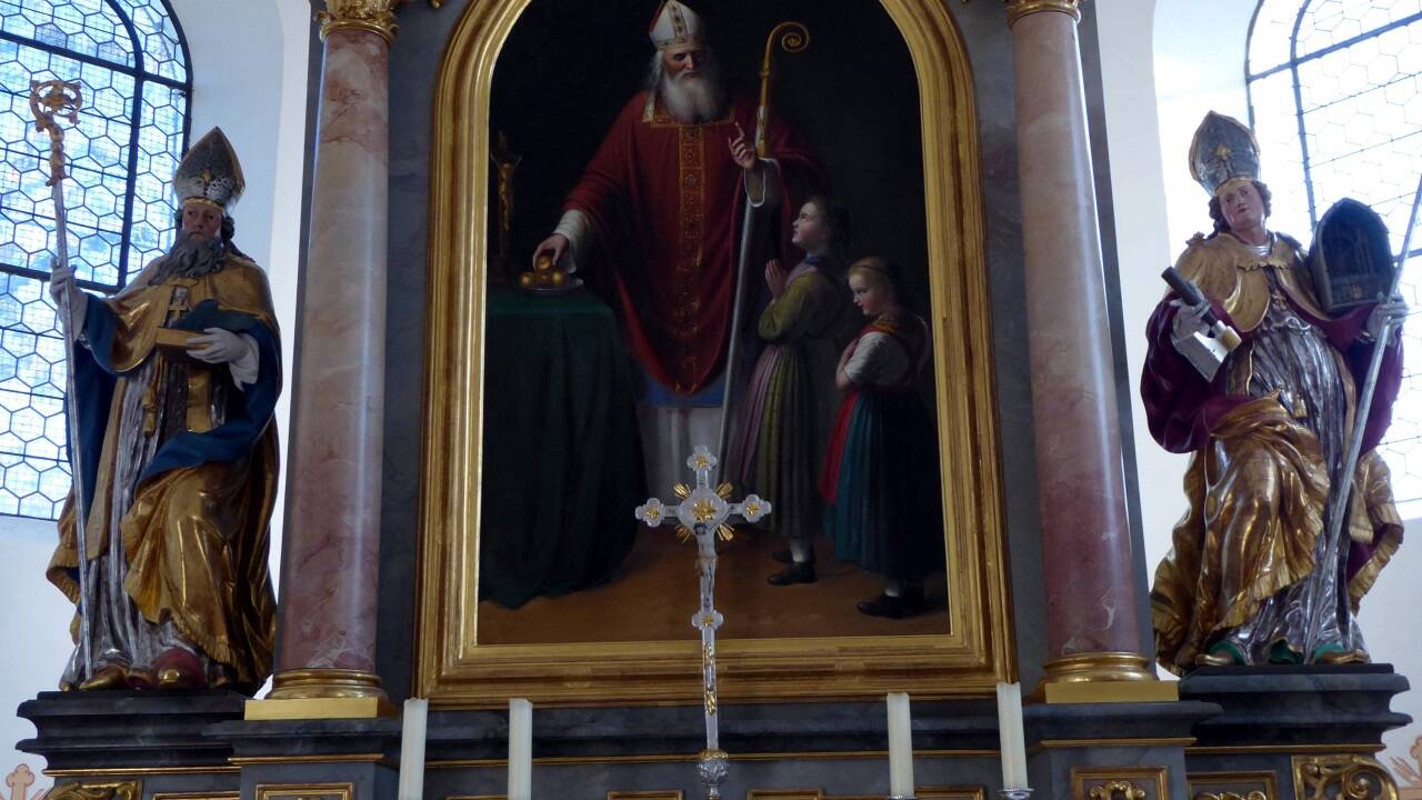 Der hl. Nikolaus verteilt Gaben, auf der Rückseite des Hochaltarbildes von Sebastian Stief hat sich Thomas Bernhard mit einer Wortspende verewigt.  