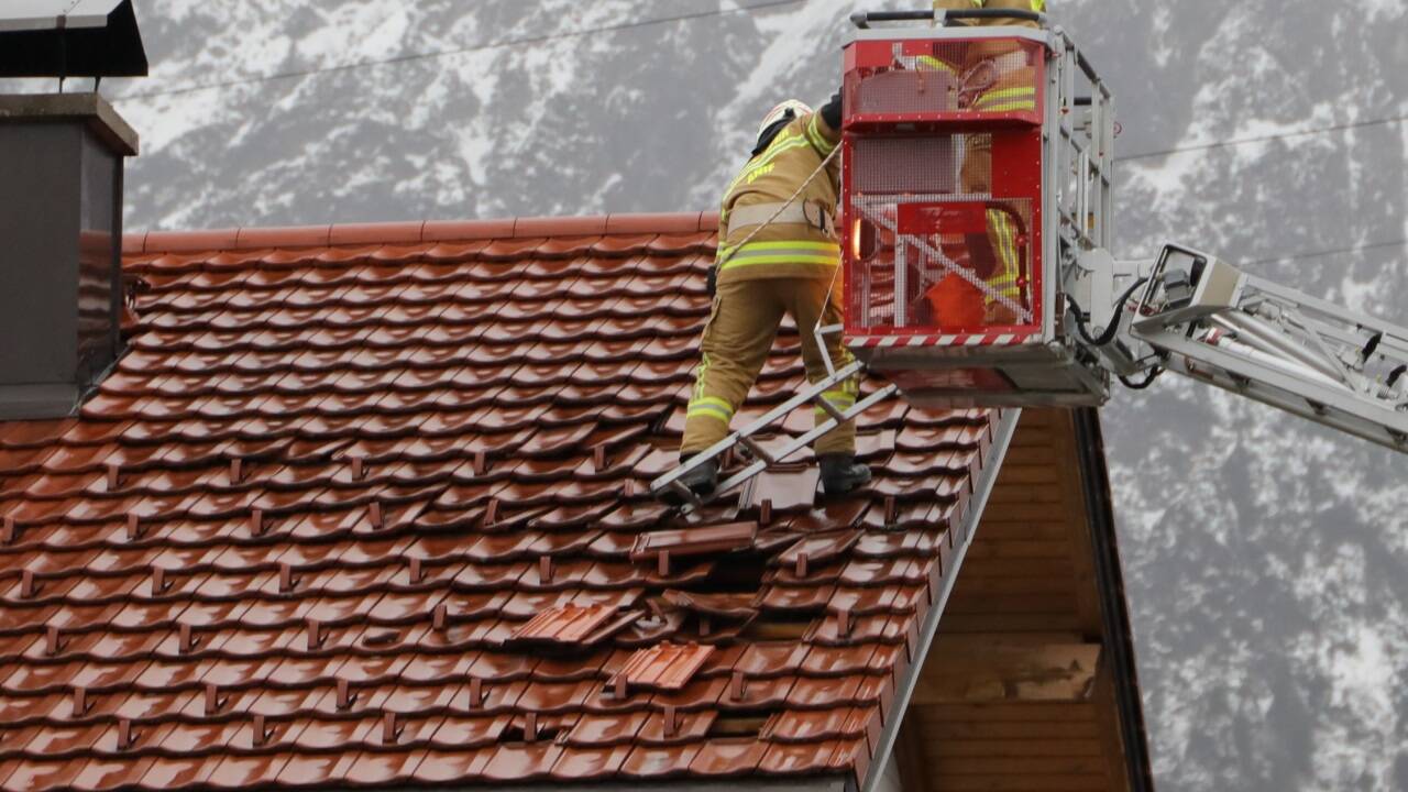 Die Feuerwehr repariert ein sturmramponiertes Dach in Niederalm. 