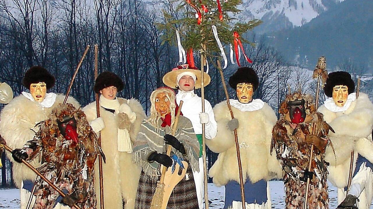 Ein Teil der Figuren des Gollinger Perchtenspiels: Frau Percht (Mitte), Sommer (weiß), Winter (neben der Frau Percht), zwei Vogelperchten und drei Fetzenperchten (Holzmasken und Felljacken). 