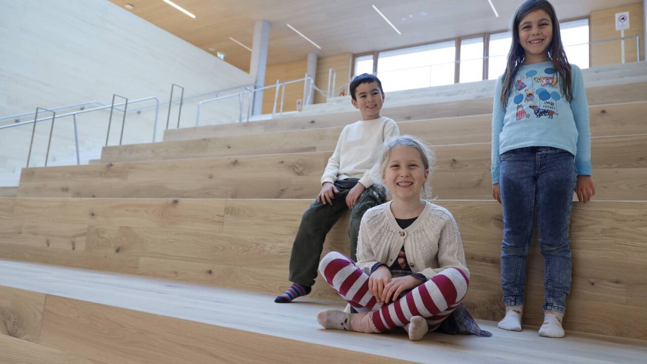 Philipp, Marlene und Giulia auf der Holztribüne.  